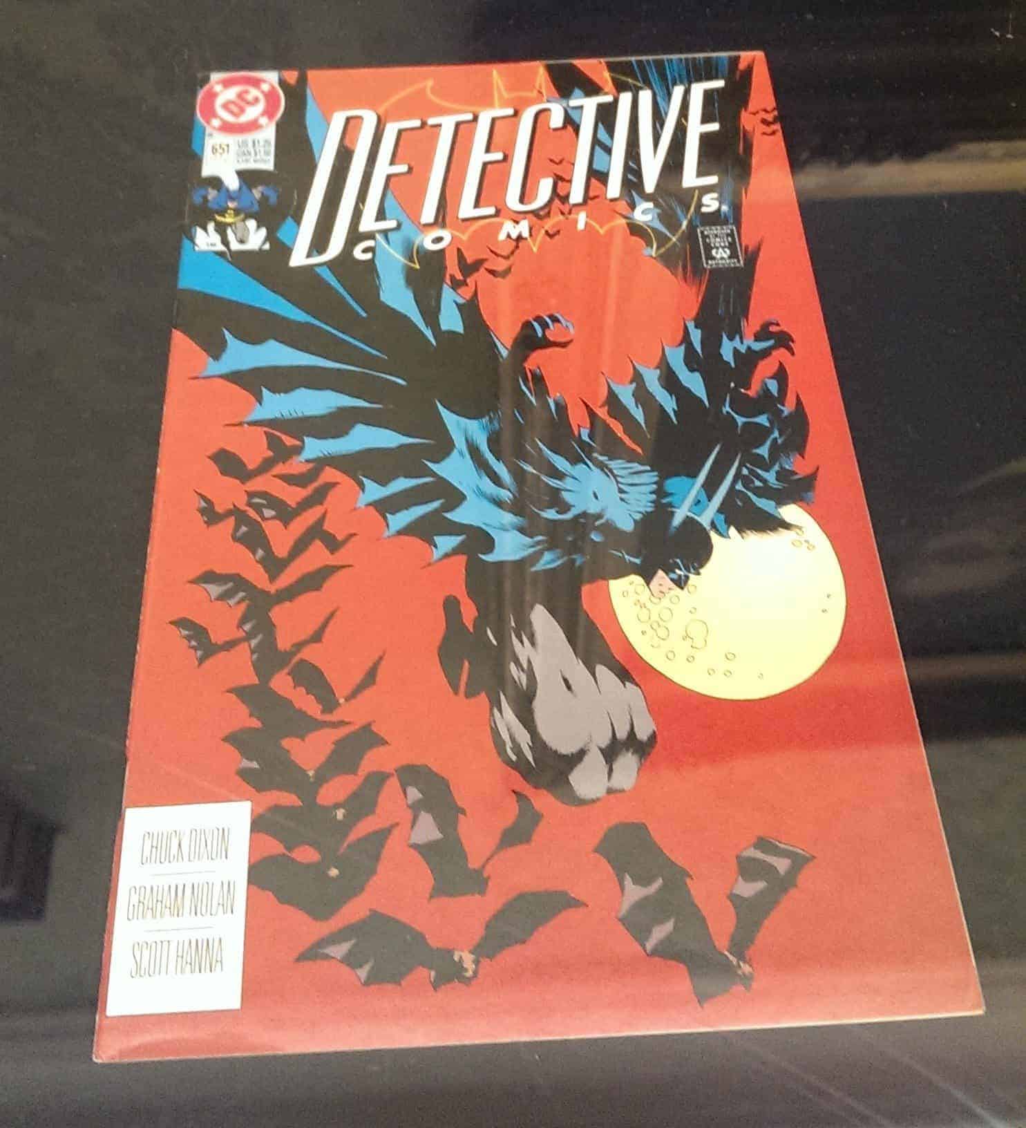 Batman descending with a flock of bats before a full moon.