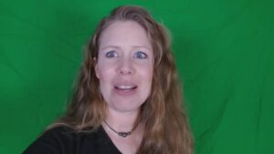 Laura looking distressed in front of green screen.